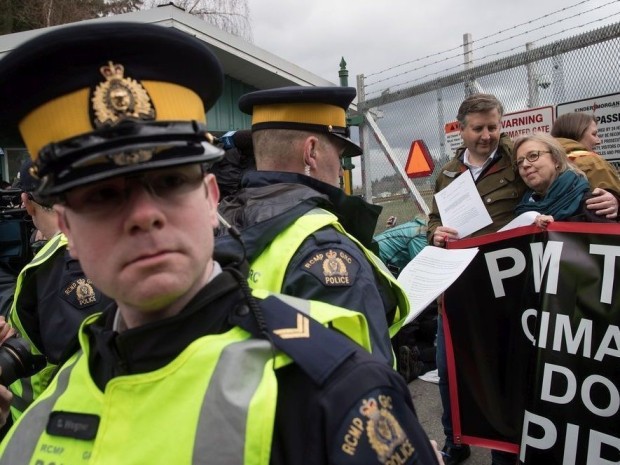 Un oficial de la Real Policía Montada lee una orden judicial a la líder del Partido Verde, Elizabeth May, derecha, y al diputado del NDP, Kennedy Stewart, segundo a la derecha, antes de ser arrestados después de unirse a los manifestantes fuera de las instalaciones del Kinder Morgan en Burnaby, Colombia Británica, el viernes 23 de marzo de 2018. Darryl Dyck / THE CANADIAN PRESS Un oficial de la Real Policía Montada lee una orden judicial a la líder del Partido Verde, Elizabeth May, derecha, y al diputado del NDP, Kennedy Stewart, segundo a la derecha, antes de ser arrestados después de unirse a los manifestantes fuera de las instalaciones del Kinder Morgan en Burnaby, Colombia Británica, el viernes 23 de marzo de 2018. Darryl Dyck / THE CANADIAN PRESS