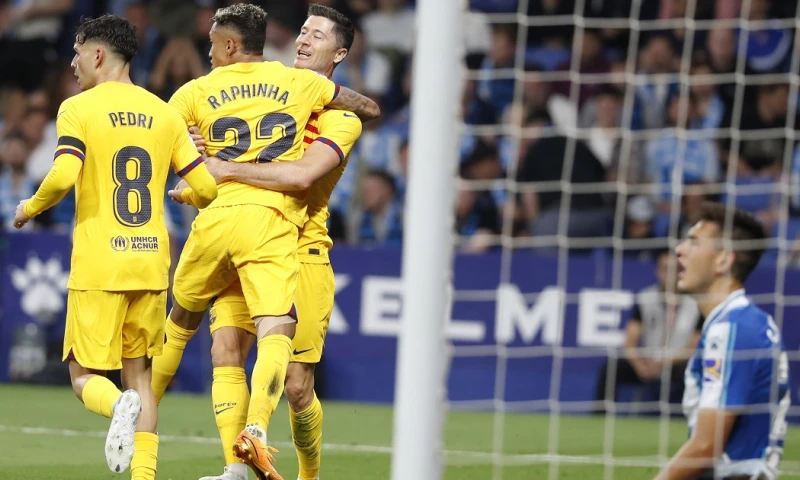 Los jugadores del FC Barcelona Pedri (i), Raphinha y Lewandowski celebran el tercer gol del equipo, ante la mirada del defensa del Espanyol César Montes / Foto: EFE