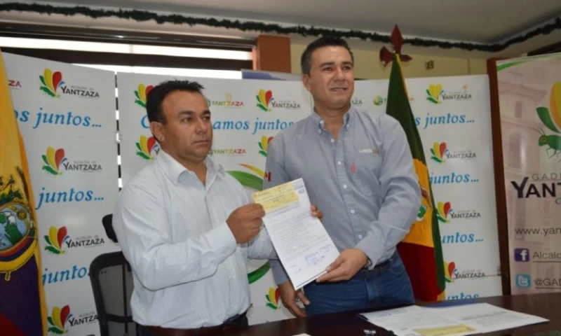 El alcalde Bladimir Armijos (I) recibe el cheque, de Winer Bravo, gerente de Responsabilidad Social y Comunidades de Lundin Gold. Foto: El Mercurio