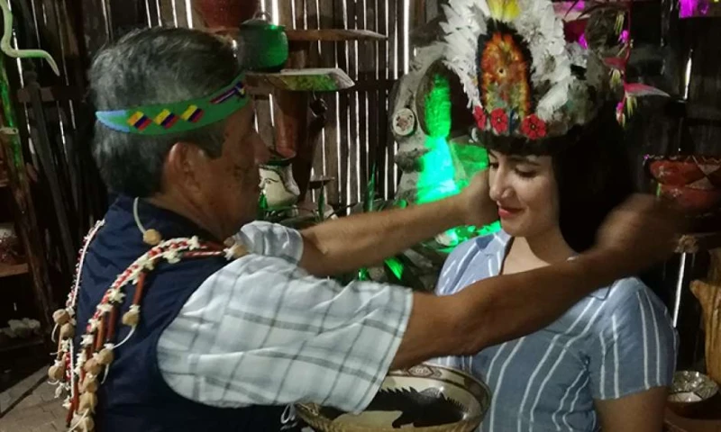 Un guía de Madre Tierra atavía a las turistas con elementos propios de su vestimenta, como coronas de plumas. Foto: El Telégrafo