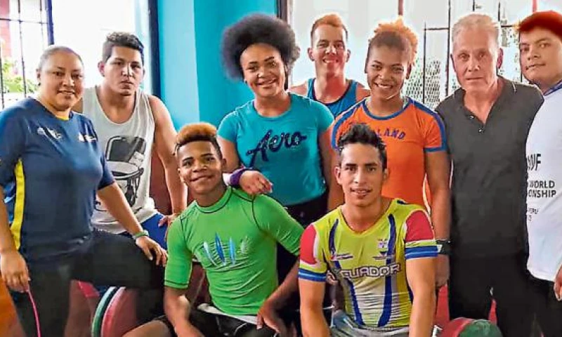 Neisi Dajomes (centro, ) junto a su hermana Paola y el entrenador Ignatov (de negro) con los pesistas de Pastaza. Foto: Martha Córdova (El Comercio)