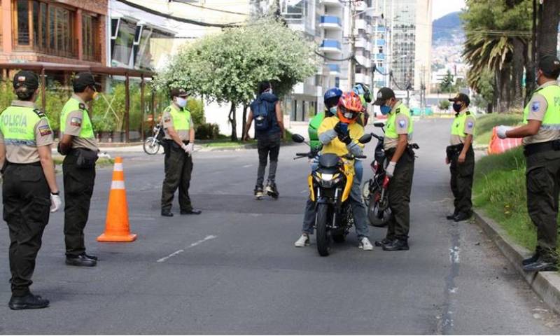 Agentes de la Policía Nacional revisan los documentos de conductores, en un puesto control en Quito. EFE