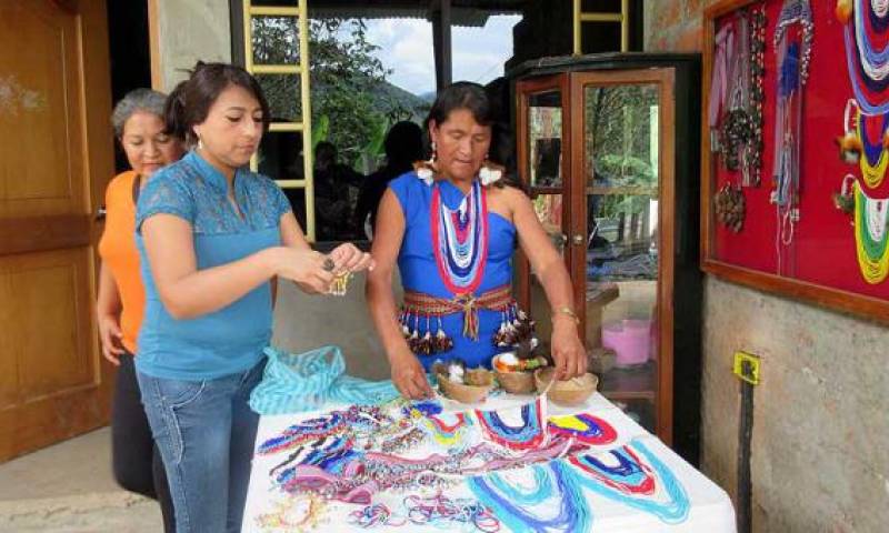 Lorena Chamba (izq.) compró los collares y aretes de plumas a Isabel Acacho (der.)